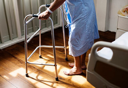 Elderly man standing with a walker