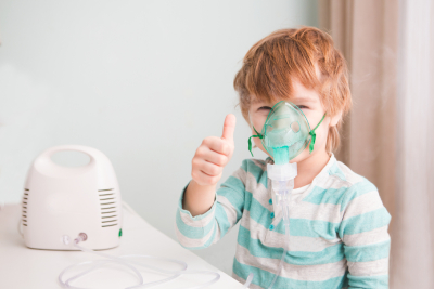 Young boy wearing a nebulizer