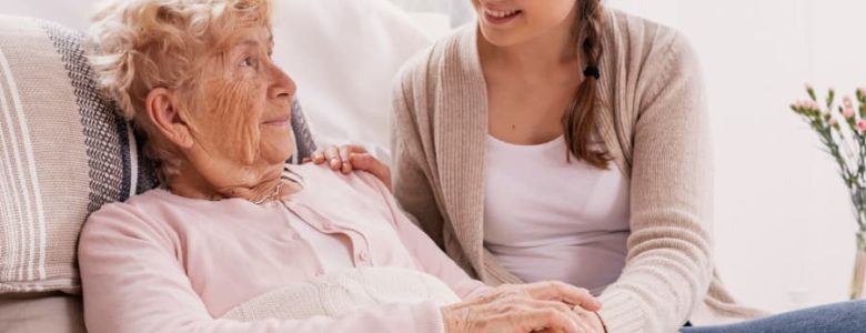 Young Adult Child Supporting Sick Parent Lying in Hospital Bed